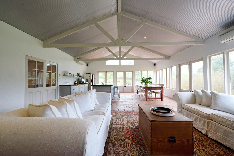 Diseño de salón abierto de estilo de casa de campo grande con suelo de ladrillo