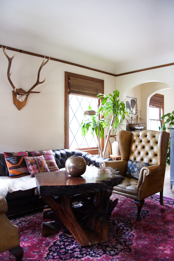 Inspiration for a small eclectic enclosed medium tone wood floor living room remodel in Seattle with white walls