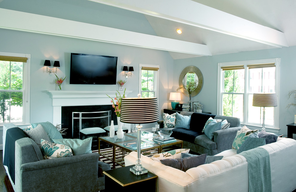 Idée de décoration pour un salon tradition avec un mur bleu, un téléviseur fixé au mur et éclairage.