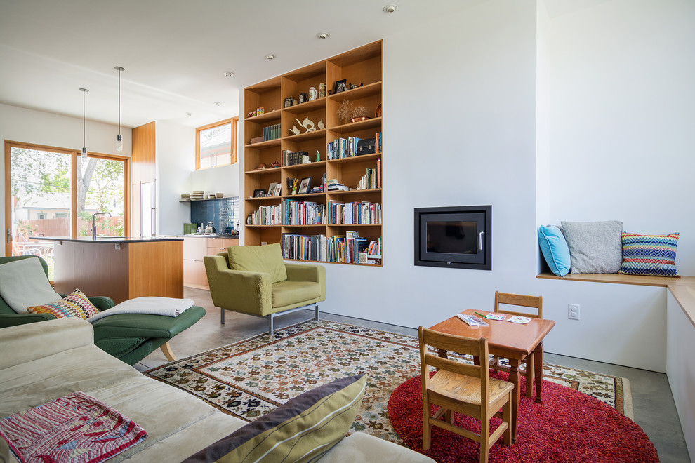 Пример оригинального дизайна: открытая гостиная комната в стиле модернизм с с книжными шкафами и полками, белыми стенами и стандартным камином