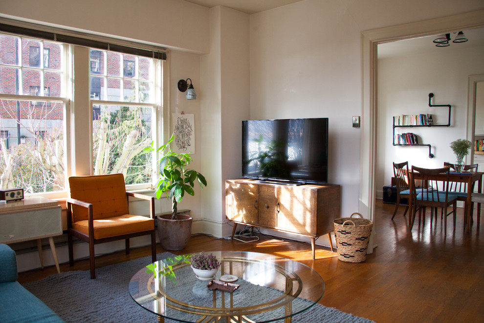 Modelo de salón cerrado ecléctico de tamaño medio con paredes blancas, suelo de madera en tonos medios y televisor independiente
