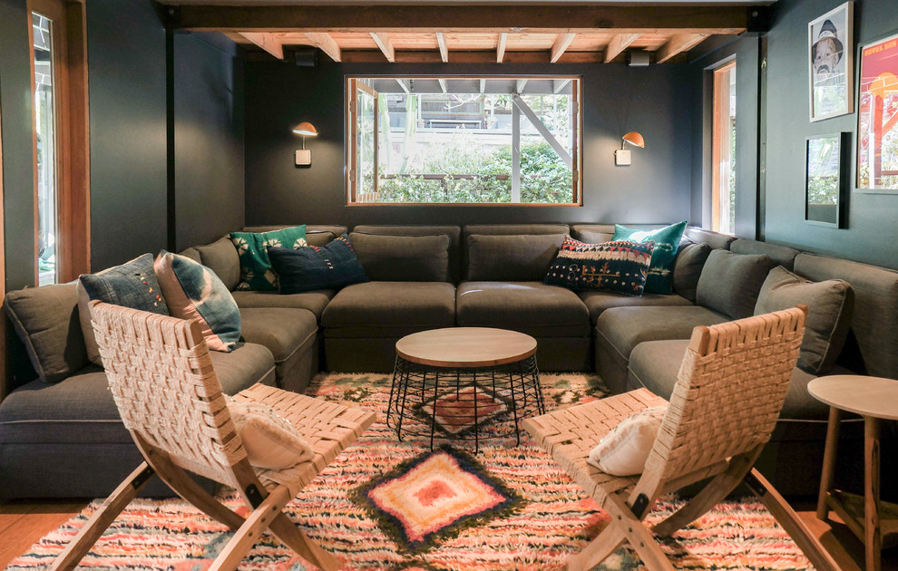 Modernes Wohnzimmer mit schwarzer Wandfarbe, braunem Holzboden und braunem Boden in Los Angeles