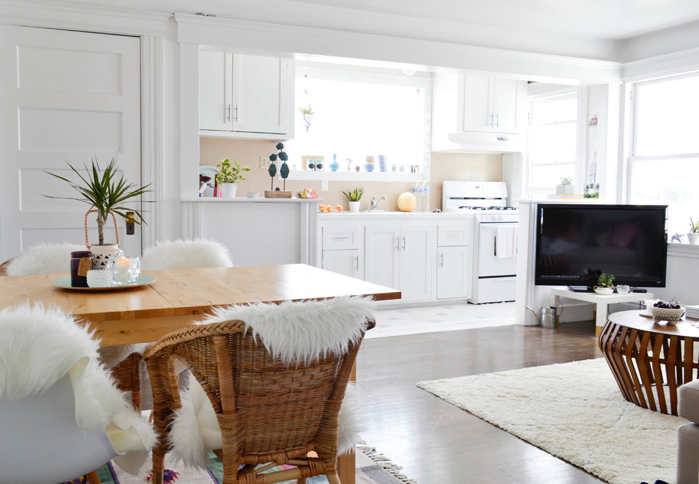 This is an example of a small bohemian open plan living room in San Francisco with white walls, dark hardwood flooring and a freestanding tv.