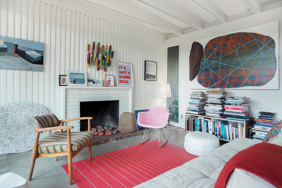 Foto på ett eklektiskt separat vardagsrum, med ett finrum, vita väggar, betonggolv, en standard öppen spis, en spiselkrans i tegelsten och grått golv