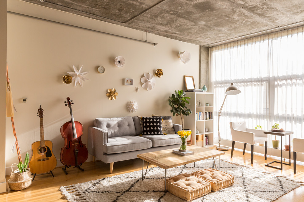 Ispirazione per un soggiorno industriale con pareti beige, pavimento in legno massello medio e pavimento marrone