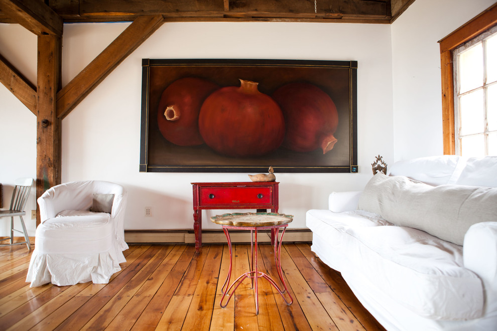 Cette photo montre un salon nature avec un mur blanc et un sol en bois brun.