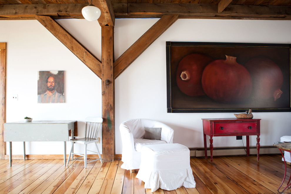 Country Wohnzimmer mit weißer Wandfarbe und braunem Holzboden in Boston