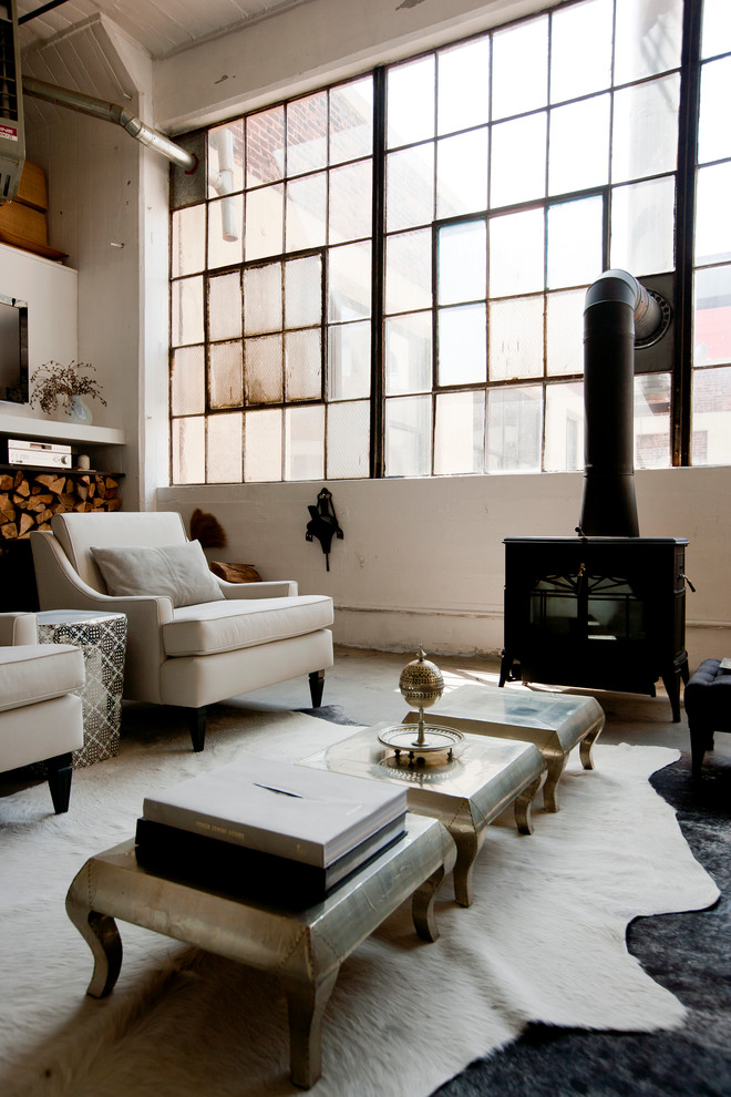 Photo of an industrial living room in New York with a wood burning stove.