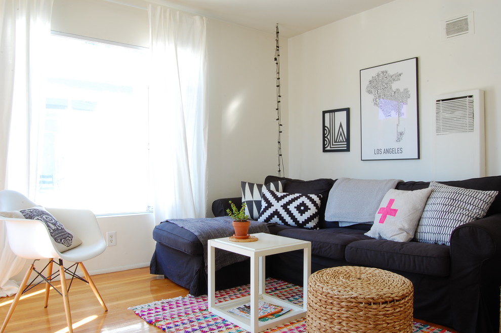 На фото: гостиная комната в стиле фьюжн с белыми стенами и светлым паркетным полом с
