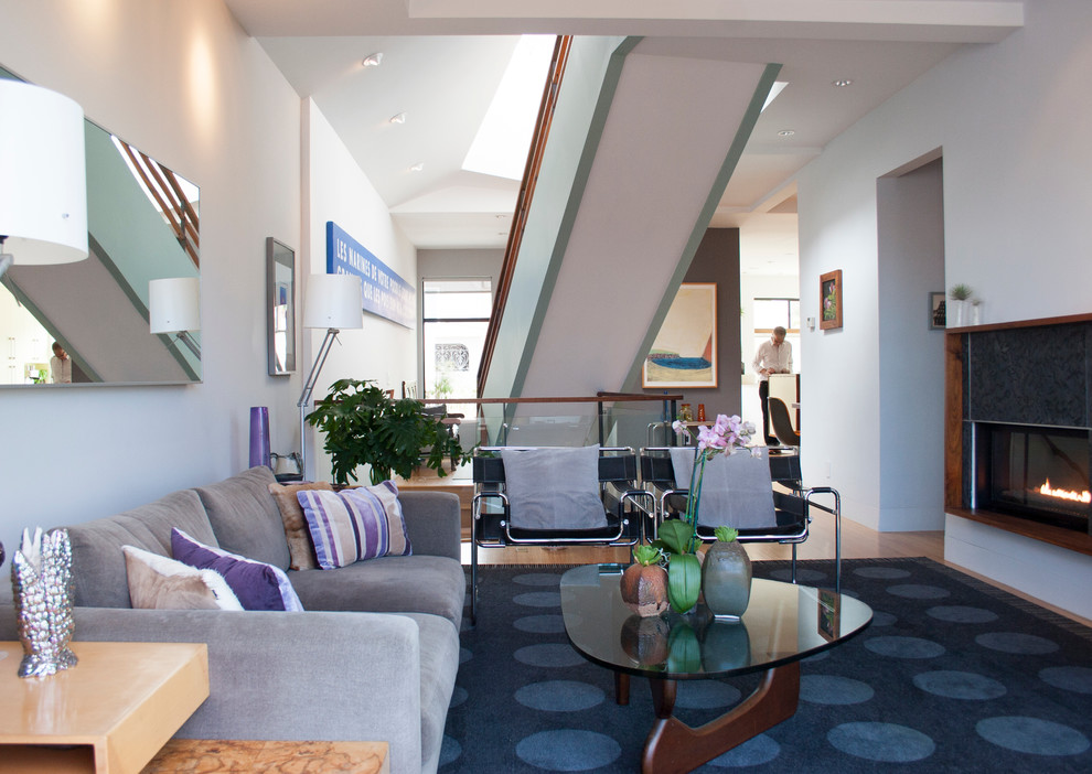 Exemple d'un salon tendance ouvert avec une salle de réception, un mur bleu, parquet clair, une cheminée ribbon et un escalier.