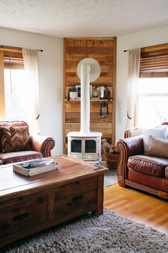 Foto de salón cerrado de estilo de casa de campo de tamaño medio con paredes blancas, suelo de madera en tonos medios, estufa de leña, marco de chimenea de madera y televisor independiente