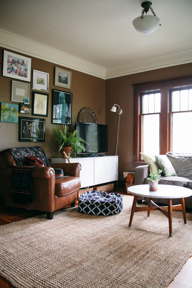 Inspiration for a medium sized eclectic enclosed living room in Seattle with brown walls, medium hardwood flooring and a freestanding tv.