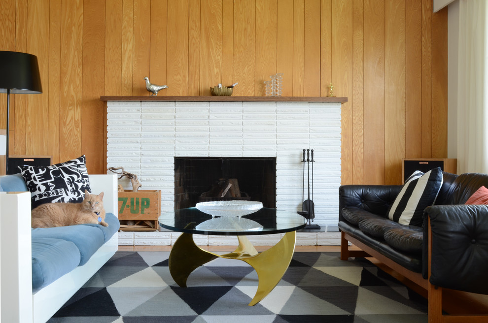 This is an example of a midcentury living room in Vancouver with a standard fireplace and a brick fireplace surround.