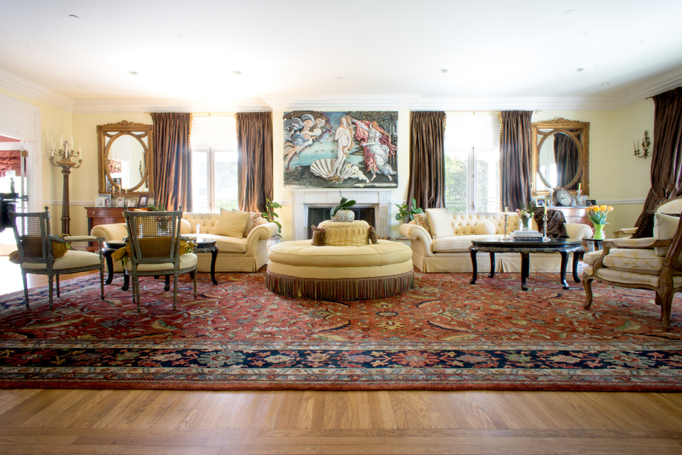 Imagen de salón para visitas tradicional con paredes amarillas, suelo de madera en tonos medios y todas las chimeneas