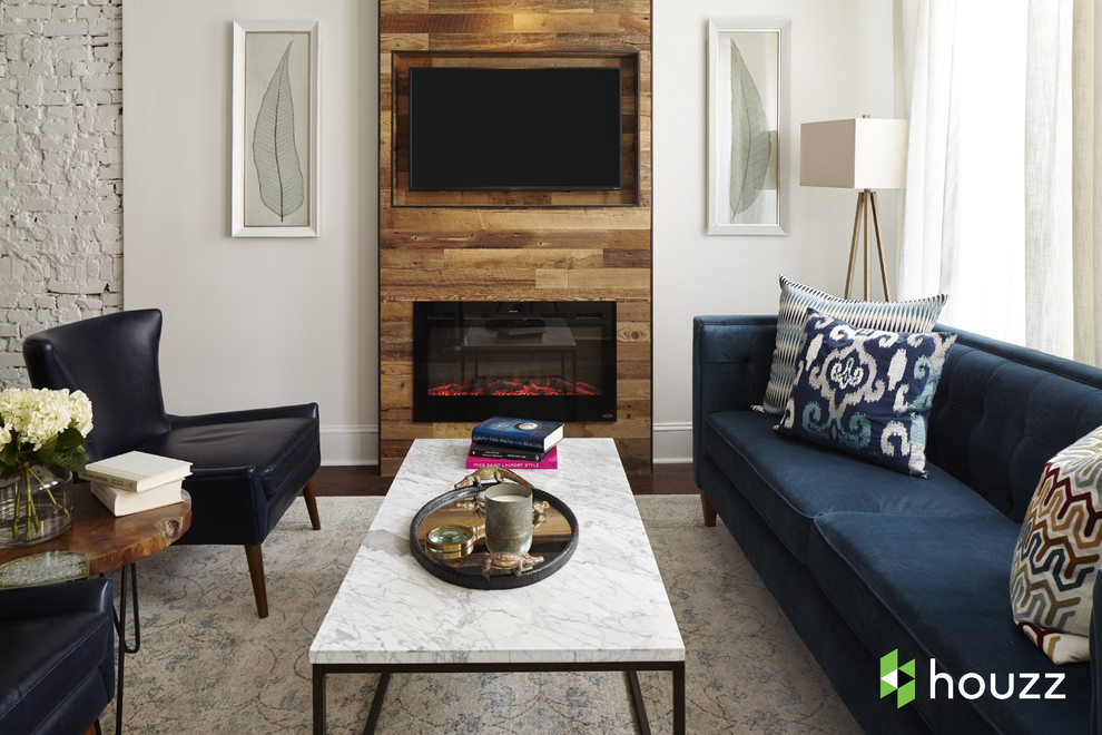 Свежая идея для дизайна: гостиная комната в стиле неоклассика (современная классика) с белыми стенами, темным паркетным полом, стандартным камином, фасадом камина из дерева, телевизором на стене и коричневым полом - отличное фото интерьера