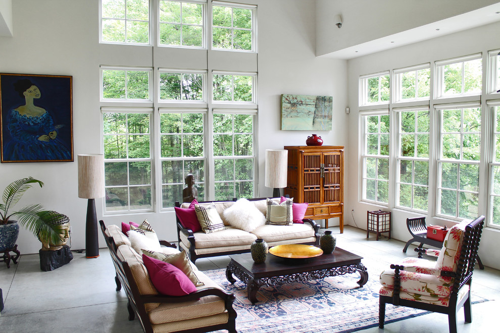 This is an example of a bohemian living room in Burlington with concrete flooring and white walls.