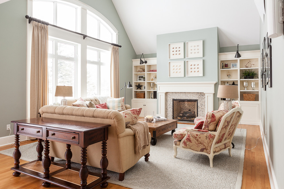Klassisches Wohnzimmer mit grüner Wandfarbe, braunem Holzboden und Kamin in Sonstige