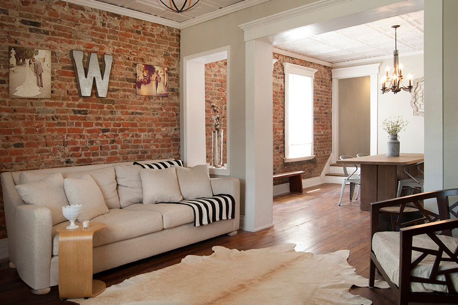 Inspiration for a small eclectic enclosed light wood floor living room remodel in Columbus with beige walls, a standard fireplace, a brick fireplace and a wall-mounted tv