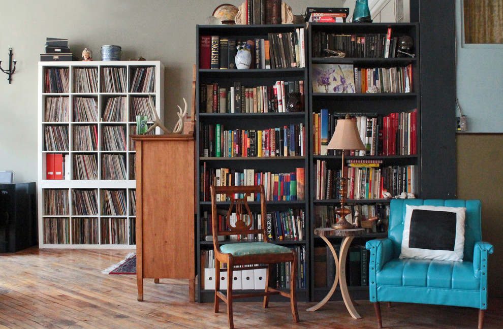 Living room library - industrial medium tone wood floor living room library idea in Montreal with beige walls