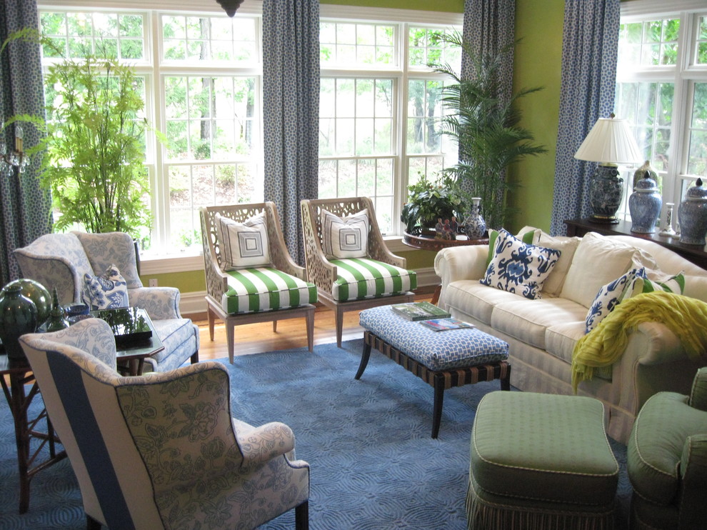 Пример оригинального дизайна: гостиная комната в классическом стиле с зелеными стенами, паркетным полом среднего тона и синими шторами