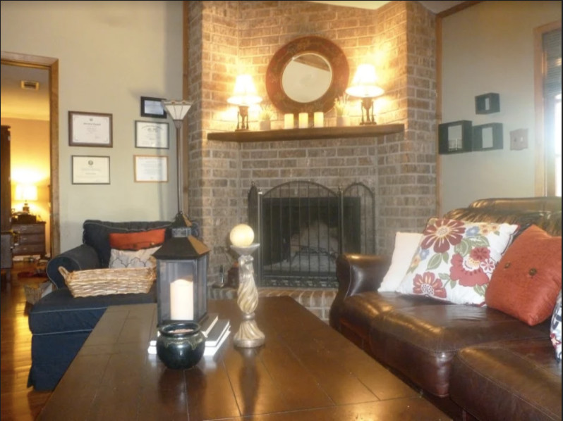 Источник вдохновения для домашнего уюта: гостиная комната среднего размера в стиле неоклассика (современная классика) с серыми стенами, угловым камином и фасадом камина из кирпича без телевизора