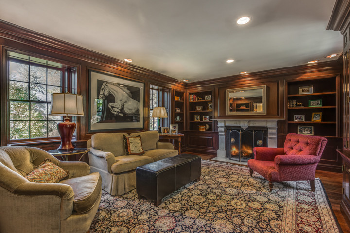 This is an example of a large classic formal enclosed living room in Boston with brown walls, medium hardwood flooring, a standard fireplace, a concrete fireplace surround and no tv.