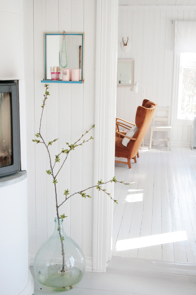 На фото: гостиная комната в скандинавском стиле с белым полом с