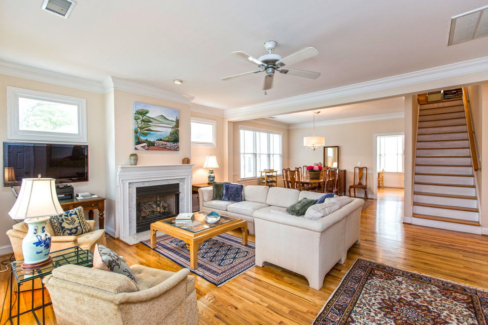 Mittelgroßes, Offenes Modernes Wohnzimmer mit beiger Wandfarbe, hellem Holzboden, Kamin und freistehendem TV in Charlotte