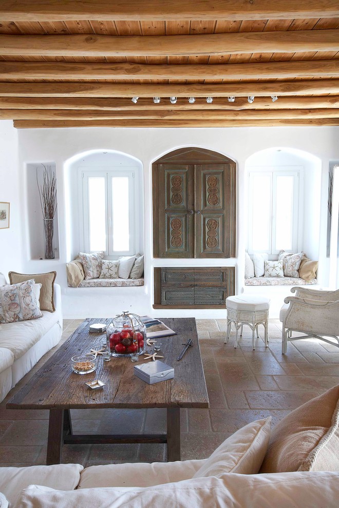Imagen de salón mediterráneo con paredes blancas y televisor retractable