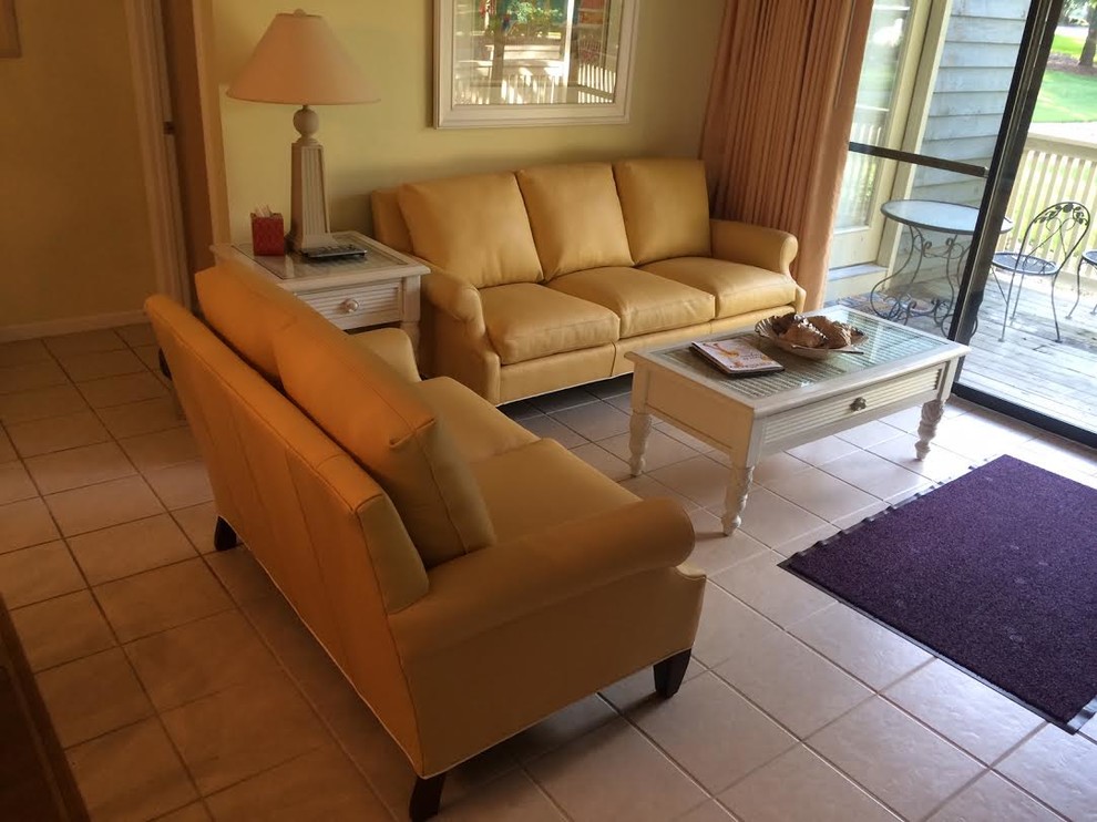 На фото: гостиная комната среднего размера в морском стиле с желтыми стенами и полом из травертина