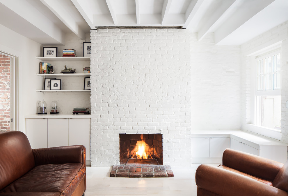 Foto de salón abierto minimalista pequeño sin televisor con paredes blancas, suelo de madera clara, todas las chimeneas y marco de chimenea de ladrillo