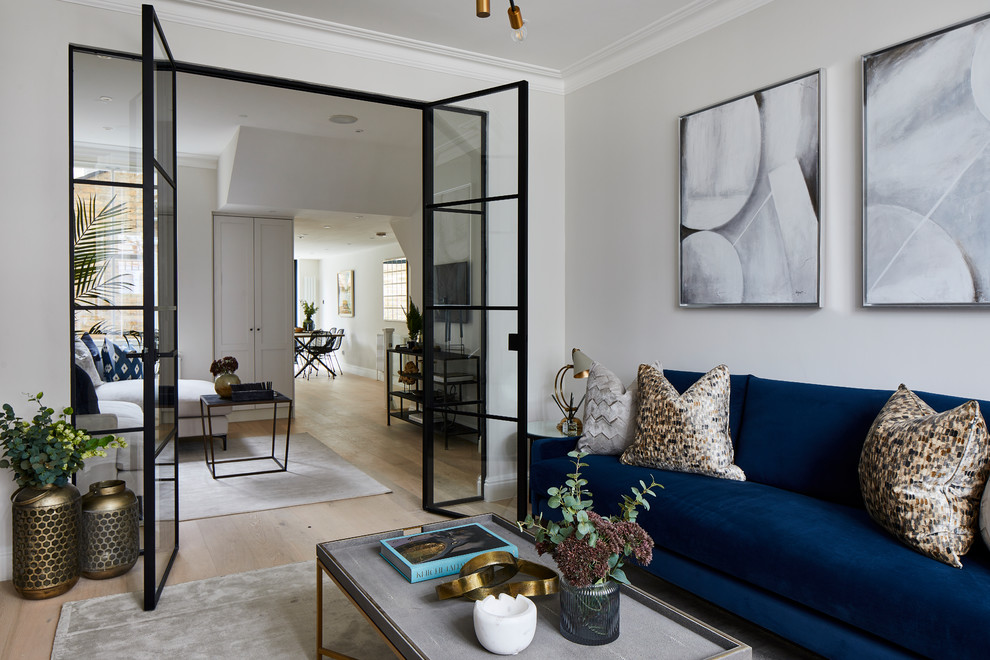 Свежая идея для дизайна: изолированная гостиная комната в стиле неоклассика (современная классика) с серыми стенами, светлым паркетным полом и синим диваном - отличное фото интерьера