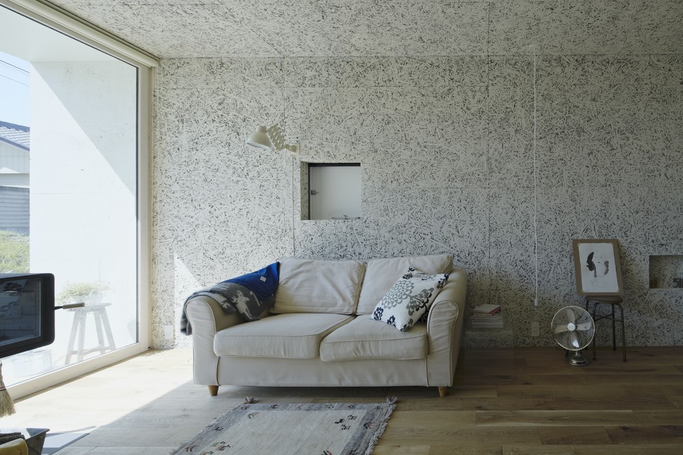 Inspiration pour un salon minimaliste avec un sol en bois brun, un mur gris et un sol marron.