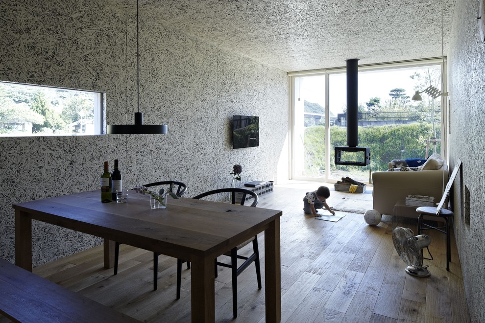 Immagine di un soggiorno moderno con camino sospeso e TV a parete