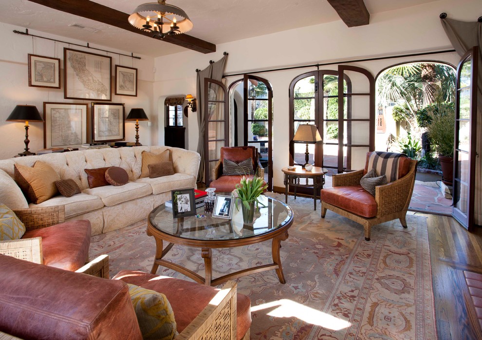 Cette image montre un salon méditerranéen avec une salle de réception, un mur beige, un sol en bois brun et éclairage.
