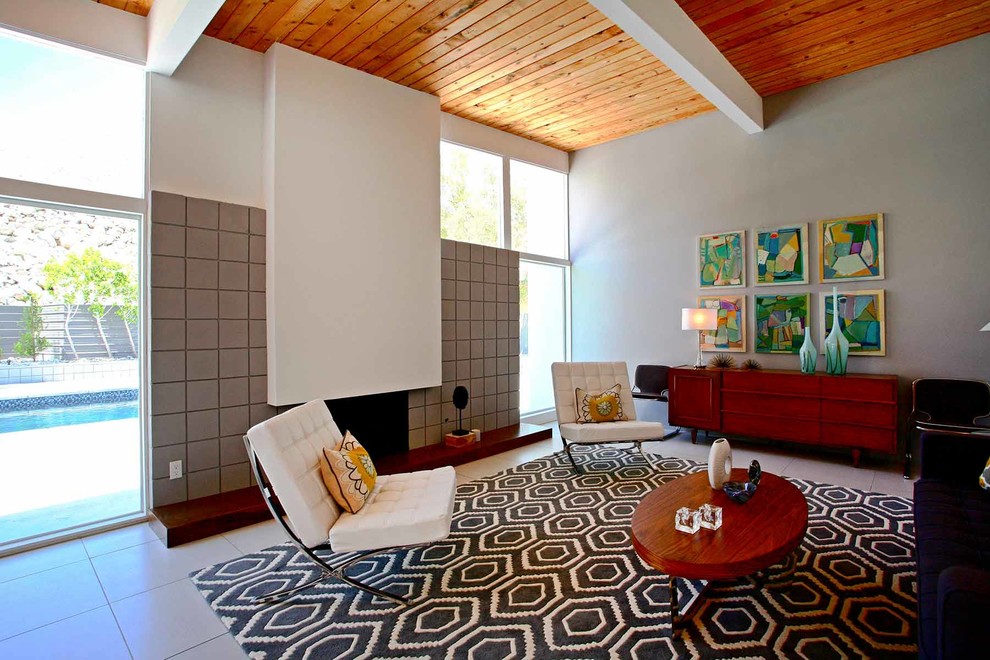 ロサンゼルスにある高級な中くらいなミッドセンチュリースタイルのおしゃれなLDK (白い壁、磁器タイルの床、標準型暖炉、コンクリートの暖炉まわり、テレビなし) の写真