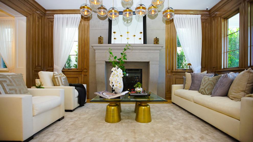 This is an example of a classic formal enclosed living room in Los Angeles with brown walls, carpet, a standard fireplace, a concrete fireplace surround and beige floors.