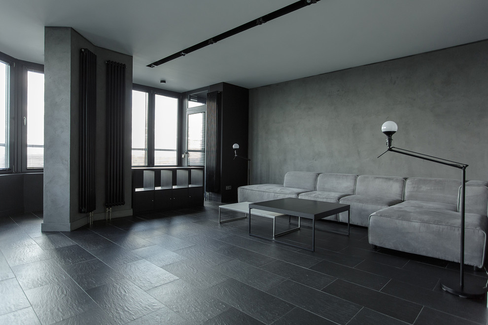 На фото: двухуровневая гостиная комната среднего размера в стиле лофт с серыми стенами, полом из керамогранита, мультимедийным центром и черным полом