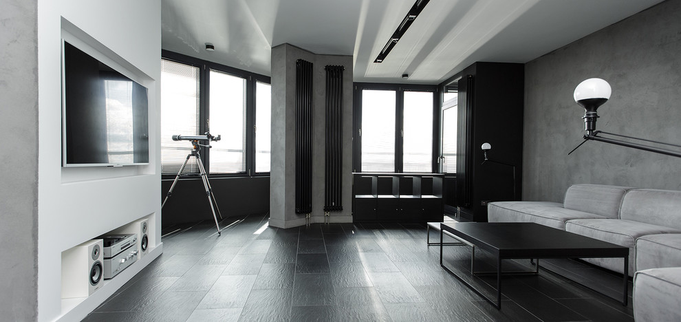 На фото: двухуровневая гостиная комната среднего размера в стиле лофт с серыми стенами, полом из керамогранита, мультимедийным центром и черным полом с