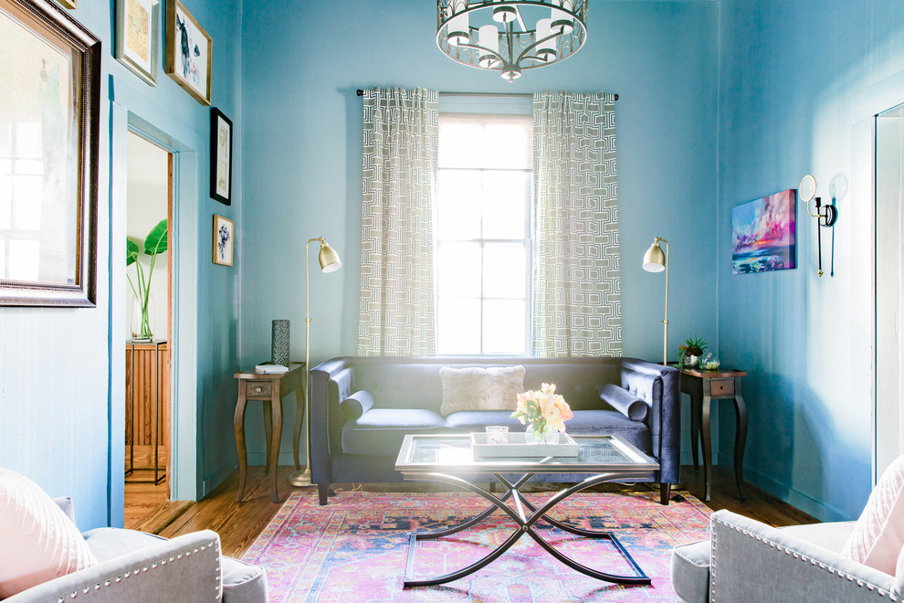 Esempio di un soggiorno country di medie dimensioni e chiuso con libreria, pareti blu, pavimento in legno massello medio e pavimento marrone