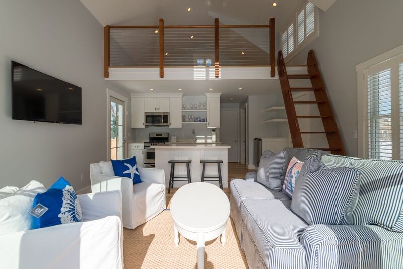 Mittelgroßes Maritimes Wohnzimmer im Loft-Stil mit Hausbar, weißer Wandfarbe, hellem Holzboden und TV-Wand in Baltimore