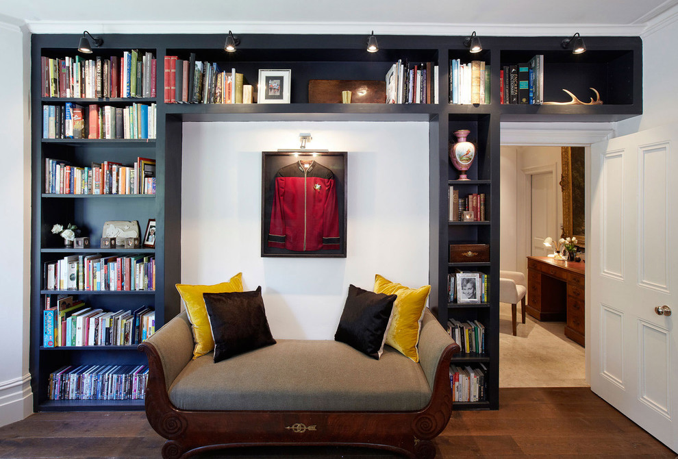 Immagine di un soggiorno classico chiuso con libreria, pareti bianche e pavimento in legno massello medio