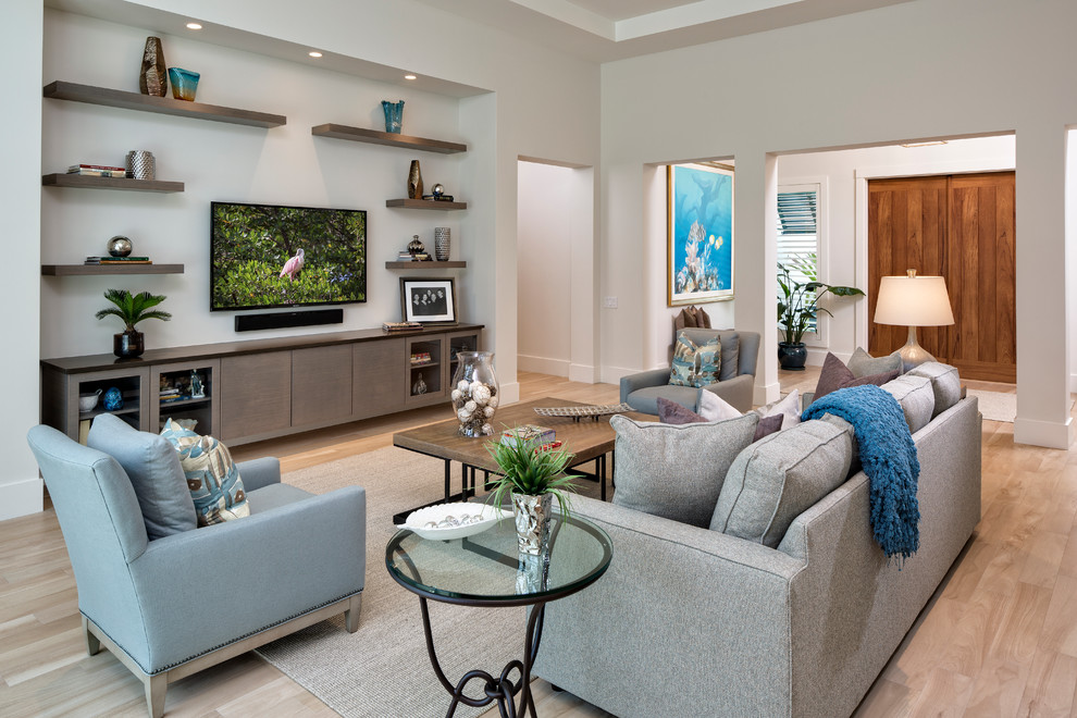 Large beach style open concept light wood floor living room photo in Miami with white walls and a wall-mounted tv