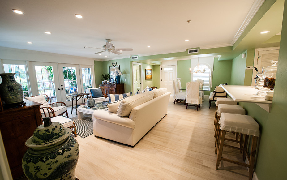 На фото: открытая гостиная комната среднего размера в классическом стиле с зелеными стенами, светлым паркетным полом и бежевым полом с