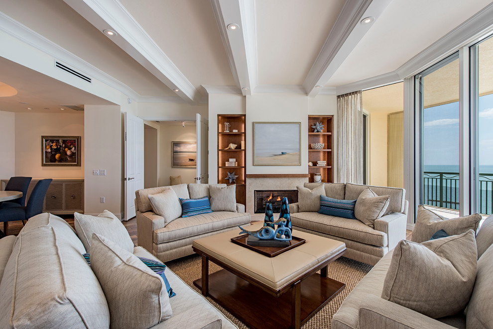 Maritimes Wohnzimmer mit beiger Wandfarbe, braunem Holzboden und Kamin in Miami