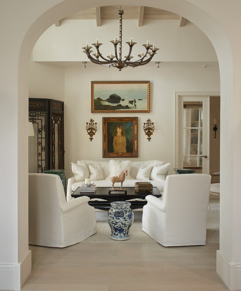 На фото: изолированная гостиная комната в средиземноморском стиле с белыми стенами и светлым паркетным полом с