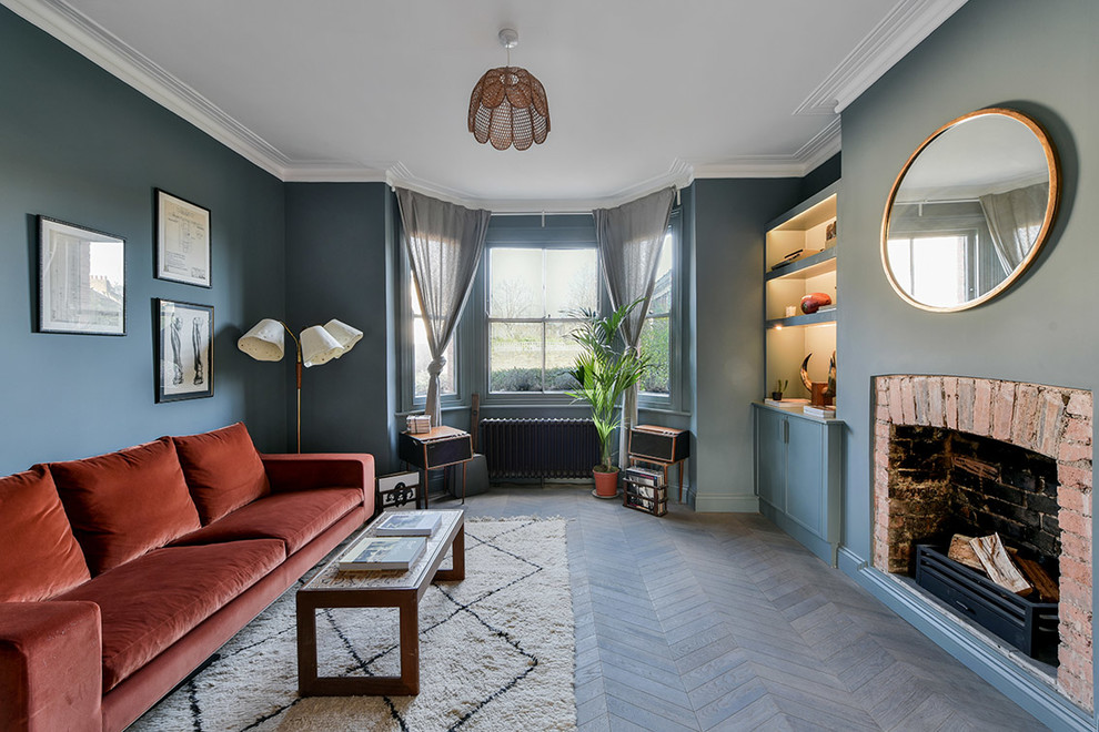 Aménagement d'un salon rétro de taille moyenne avec un mur bleu, parquet foncé et un sol marron.