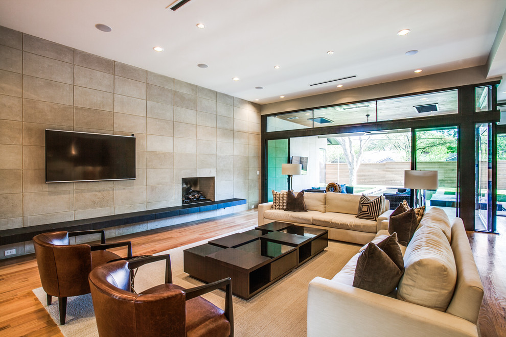 Contemporary open plan living room feature wall in Dallas with beige walls, dark hardwood flooring, a standard fireplace, a tiled fireplace surround and brown floors.