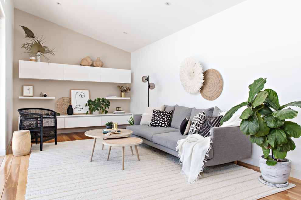 Immagine di un soggiorno stile marinaro di medie dimensioni e aperto con nessun camino, pareti bianche, pavimento in legno massello medio e pavimento marrone