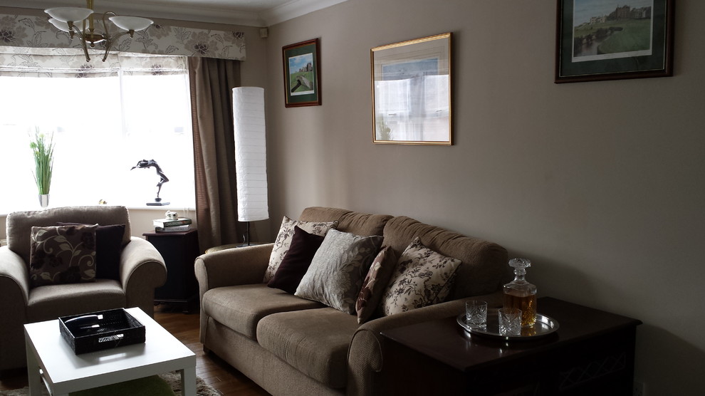 Imagen de salón cerrado de estilo de casa de campo de tamaño medio con paredes beige, suelo de madera en tonos medios y televisor colgado en la pared